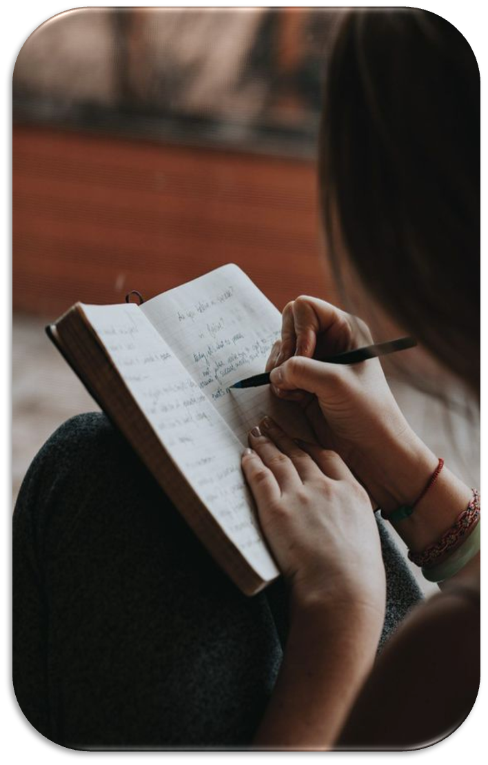 Persona escribiendo en cuaderno, simbolizando planificación, reflexión y desarrollo de objetivos